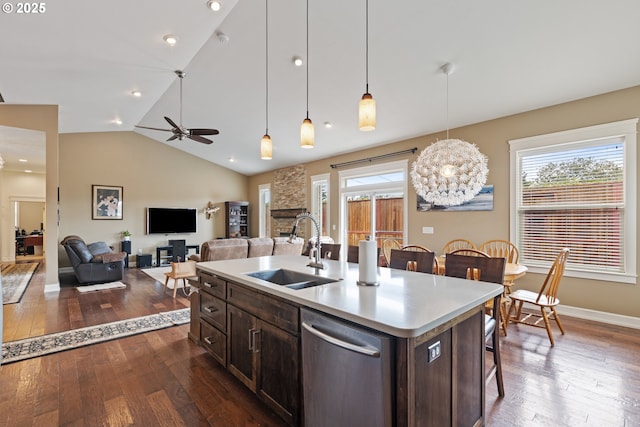 kitchen with a sink, stainless steel dishwasher, lofted ceiling, a breakfast bar, and dark brown cabinetry
