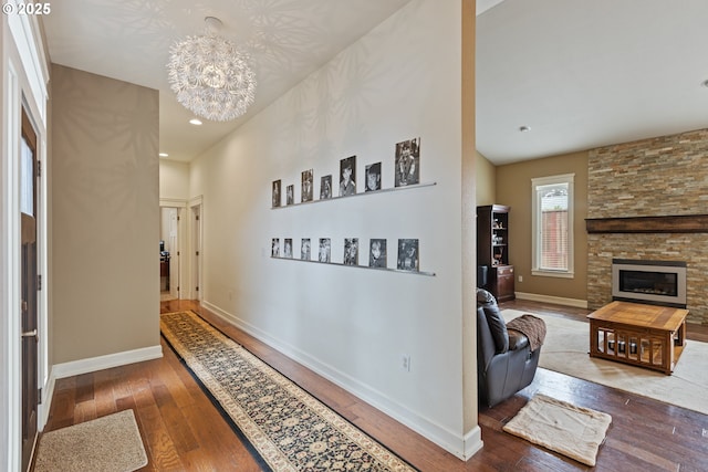 hallway with hardwood / wood-style flooring, a chandelier, baseboards, and recessed lighting