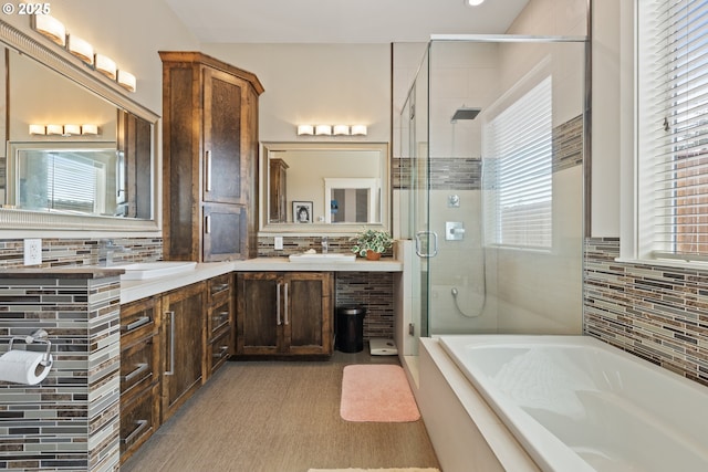 full bath featuring a shower stall, a bath, tasteful backsplash, double vanity, and recessed lighting