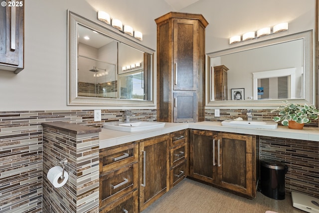 bathroom featuring a shower stall, tasteful backsplash, and double vanity