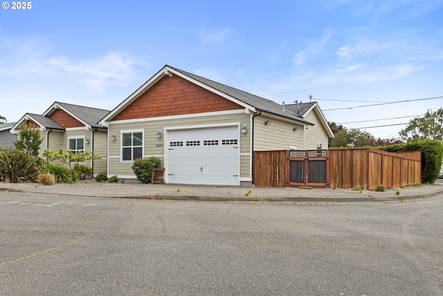 view of front of house featuring fence and a garage
