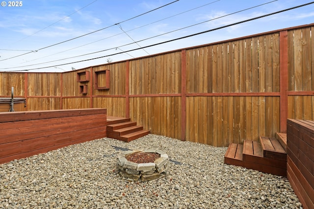 view of yard with fence and an outdoor fire pit