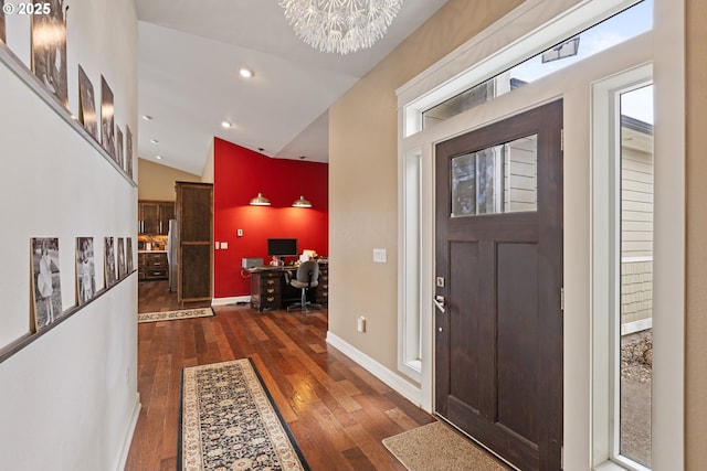 foyer entrance with vaulted ceiling, wood-type flooring, recessed lighting, a chandelier, and baseboards