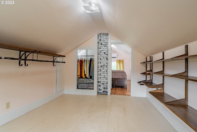 additional living space featuring wood finished floors and vaulted ceiling