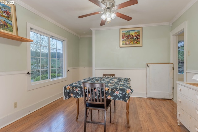 dining space with a ceiling fan, baseboards, ornamental molding, and wood finished floors