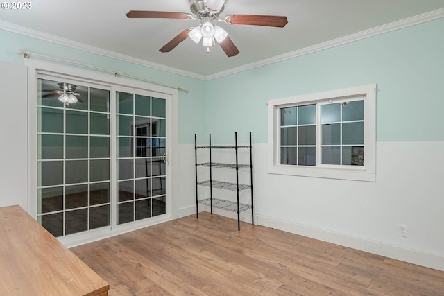 empty room with baseboards, ornamental molding, a ceiling fan, and wood finished floors