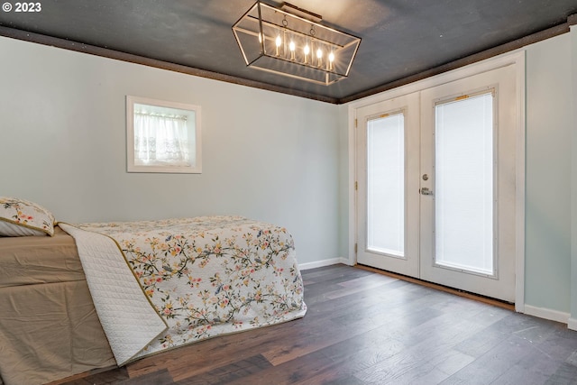 bedroom featuring french doors, baseboards, wood finished floors, and a chandelier