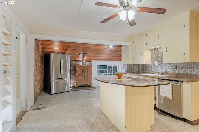 kitchen with decorative backsplash, a ceiling fan, a center island, a sink, and appliances with stainless steel finishes