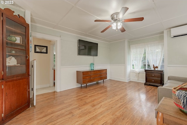 living room with an AC wall unit, ceiling fan, and light wood-type flooring