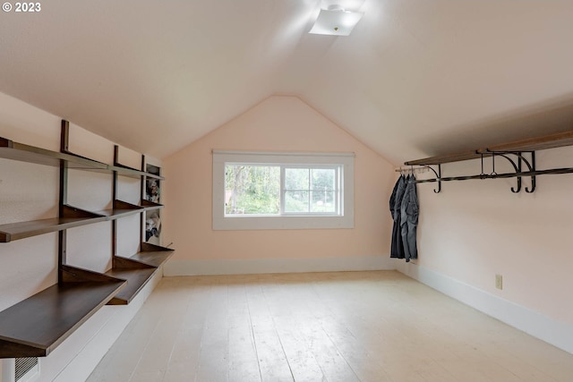 additional living space featuring baseboards, wood finished floors, and lofted ceiling