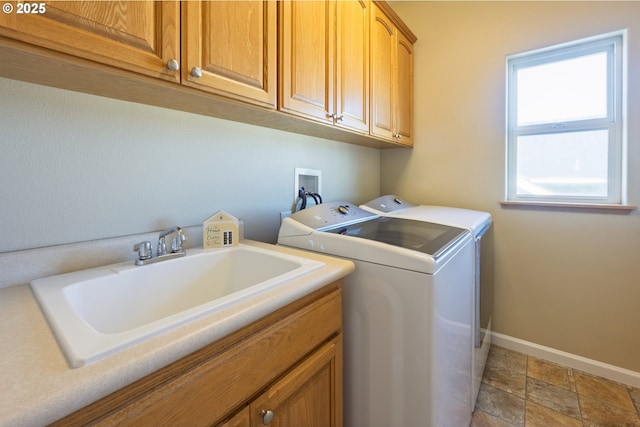 1587 NW 39th St, Lincoln City, OR 97367 - laundry room featuring washing machine and dryer, baseboards, stone finish floor, a sink, and cabinet space