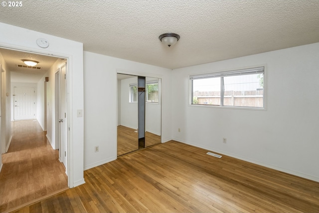 730 SW Dolph St, Portland, OR 97219 - unfurnished bedroom featuring light wood-style floors, a closet, and a textured ceiling