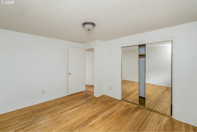 730 SW Dolph St, Portland, OR 97219 - unfurnished bedroom with light wood finished floors, a closet, and a textured ceiling