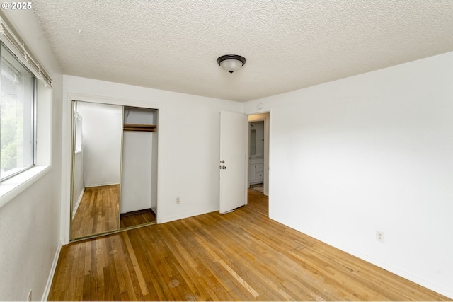 730 SW Dolph St, Portland, OR 97219 - unfurnished bedroom featuring a closet, light wood-style floors, and a textured ceiling