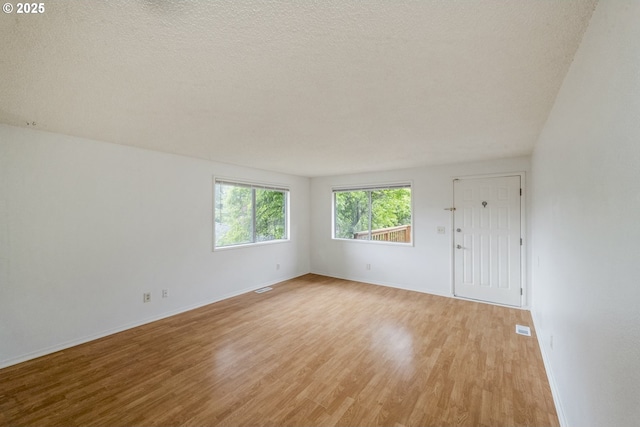 730 SW Dolph St, Portland, OR 97219 - unfurnished room featuring light wood-style flooring and a textured ceiling