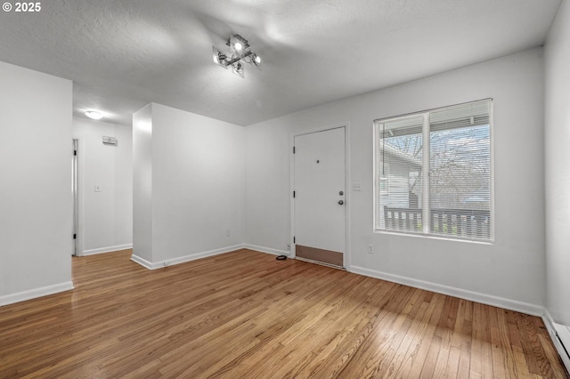 6125 S Hood Ave, Portland, OR 97239 - interior space with baseboards, a textured ceiling, and light wood finished floors