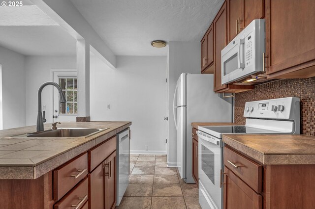 6125 S Hood Ave, Portland, OR 97239 - kitchen featuring a sink, backsplash, white appliances, brown cabinetry, and baseboards