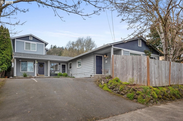 view of front of home featuring driveway and fence