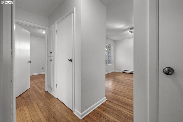 6125 S Hood Ave, Portland, OR 97239 - hallway with baseboard heating, baseboards, and wood-type flooring