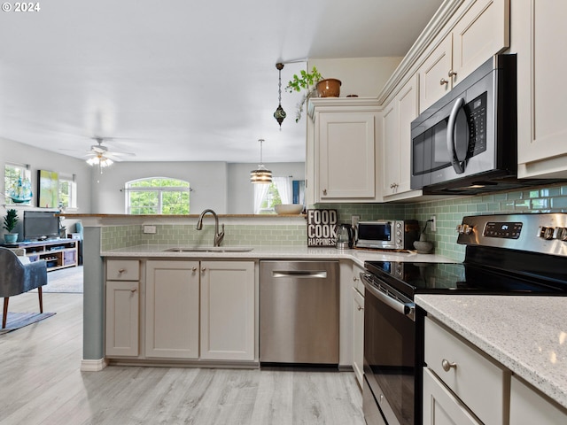 1170 NE 64th Ln Unit 1209, Hillsboro, OR 97124 - kitchen featuring appliances with stainless steel finishes, a peninsula, tasteful backsplash, a ceiling fan, and light wood-type flooring