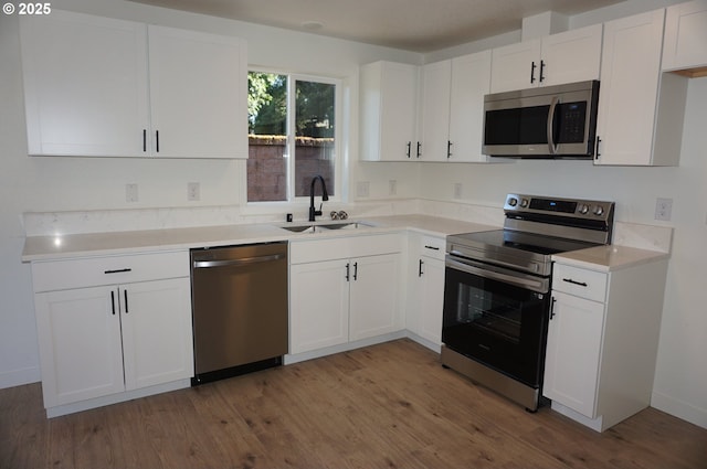7012 NE 149th Ct, Vancouver, WA 98682 - kitchen with appliances with stainless steel finishes, a sink, wood finished floors, and white cabinetry