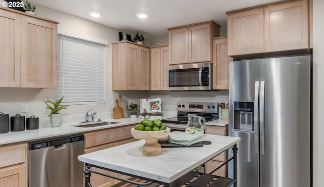 kitchen featuring appliances with stainless steel finishes, light brown cabinetry, a sink, light countertops, and recessed lighting