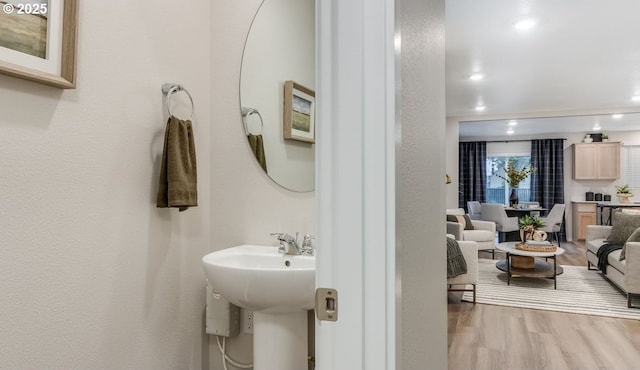 bathroom featuring wood finished floors, a sink, and recessed lighting