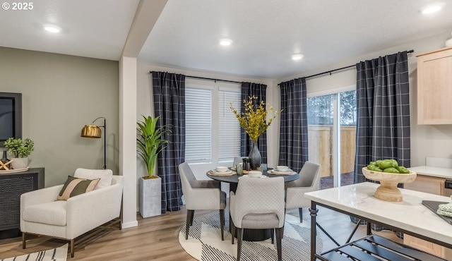 dining room with light wood-type flooring and recessed lighting