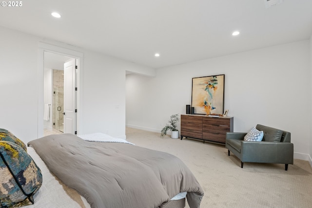 bedroom with connected bathroom and light colored carpet