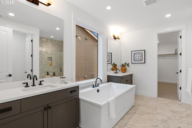 bathroom with vanity and shower with separate bathtub