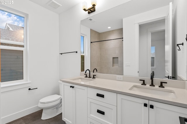 bathroom with tile patterned flooring, vanity, plenty of natural light, and toilet