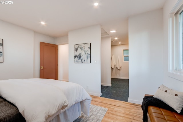 bedroom with multiple windows and hardwood / wood-style flooring