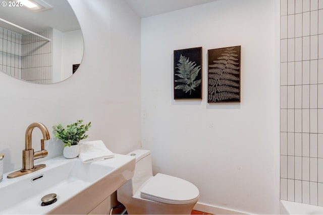 bathroom featuring toilet, sink, and walk in shower