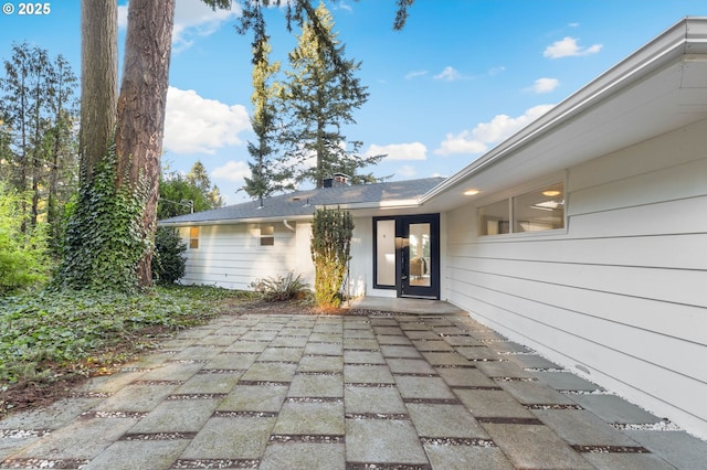 view of exterior entry with a patio area