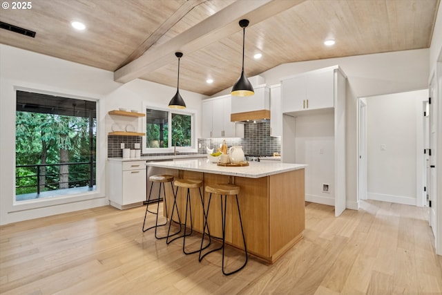 17253 SW Rivendell Dr, Portland, OR 97224 - kitchen featuring stainless steel dishwasher, white cabinets, a kitchen island, light wood finished floors, and lofted ceiling