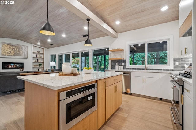 17253 SW Rivendell Dr, Portland, OR 97224 - kitchen featuring stainless steel appliances, wood ceiling, a center island, light stone countertops, and a glass covered fireplace