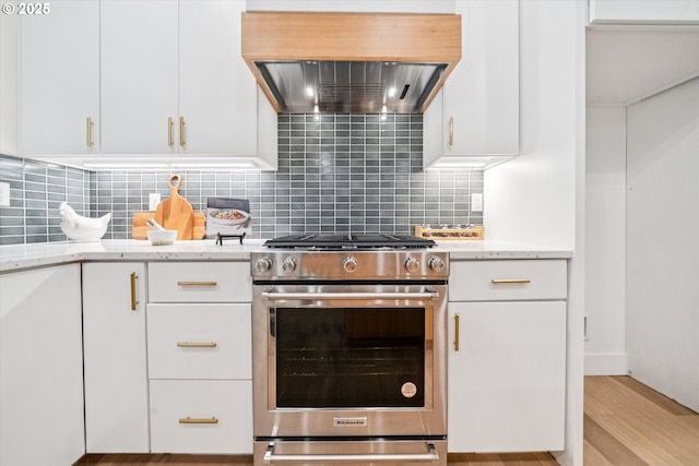 17253 SW Rivendell Dr, Portland, OR 97224 - kitchen with stainless steel gas stove, ventilation hood, light stone countertops, tasteful backsplash, and light wood-type flooring