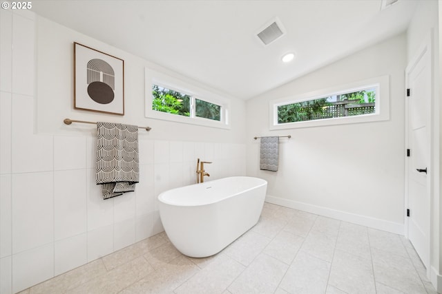17253 SW Rivendell Dr, Portland, OR 97224 - bathroom with healthy amount of natural light, a soaking tub, lofted ceiling, tile walls, and tile patterned floors