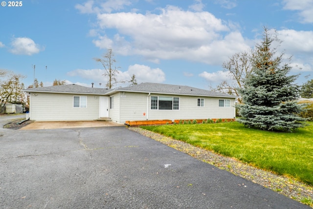 ranch-style house with aphalt driveway and a front yard