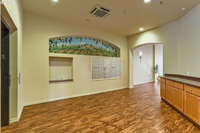 unfurnished room with dark hardwood / wood-style flooring and mail boxes