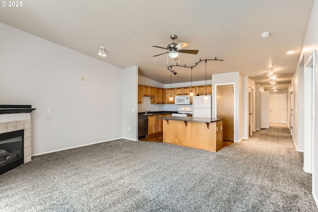 kitchen featuring a center island, dark carpet, white appliances, a kitchen breakfast bar, and hanging light fixtures