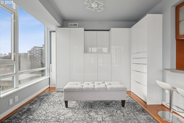 sitting room featuring visible vents, baseboards, and wood finished floors