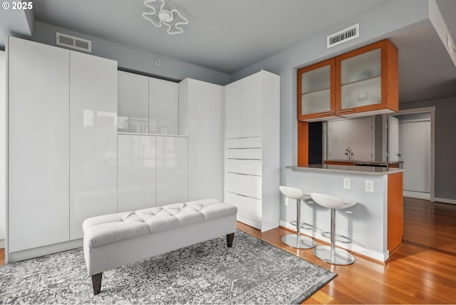 bathroom with wood finished floors, visible vents, and baseboards