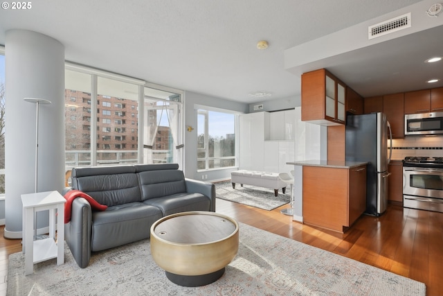 living room featuring visible vents, a view of city, and wood finished floors