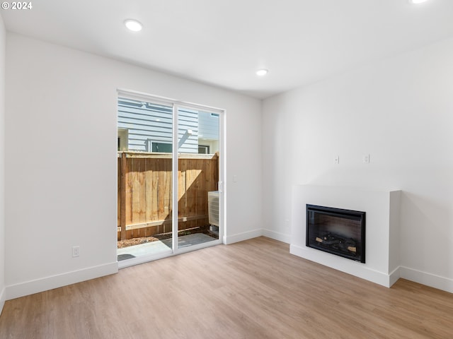 6611 N Fessenden St, Portland, OR 97203 - unfurnished living room featuring wood finished floors, a glass covered fireplace, baseboards, and recessed lighting