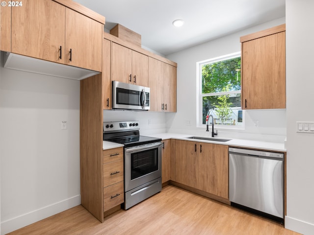 6611 N Fessenden St, Portland, OR 97203 - kitchen with appliances with stainless steel finishes, a sink, light wood-style flooring, light countertops, and light brown cabinets