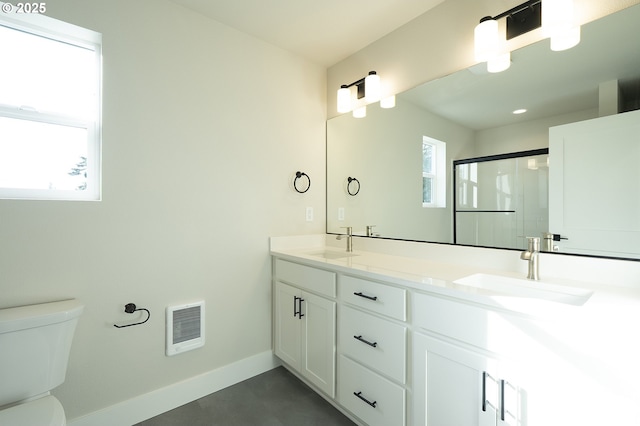 bathroom with vanity, a shower with door, and toilet