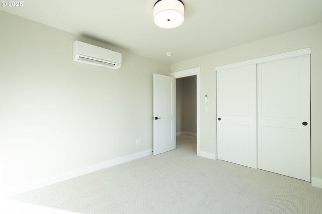 unfurnished bedroom featuring an AC wall unit, light colored carpet, and a closet