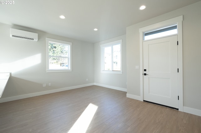 entryway featuring light hardwood / wood-style flooring, an AC wall unit, and a healthy amount of sunlight