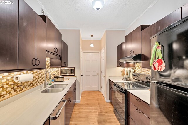 4320 S Corbett Ave Unit 302, Portland, OR 97239 - kitchen with appliances with stainless steel finishes, a sink, under cabinet range hood, light wood-style floors, and light countertops